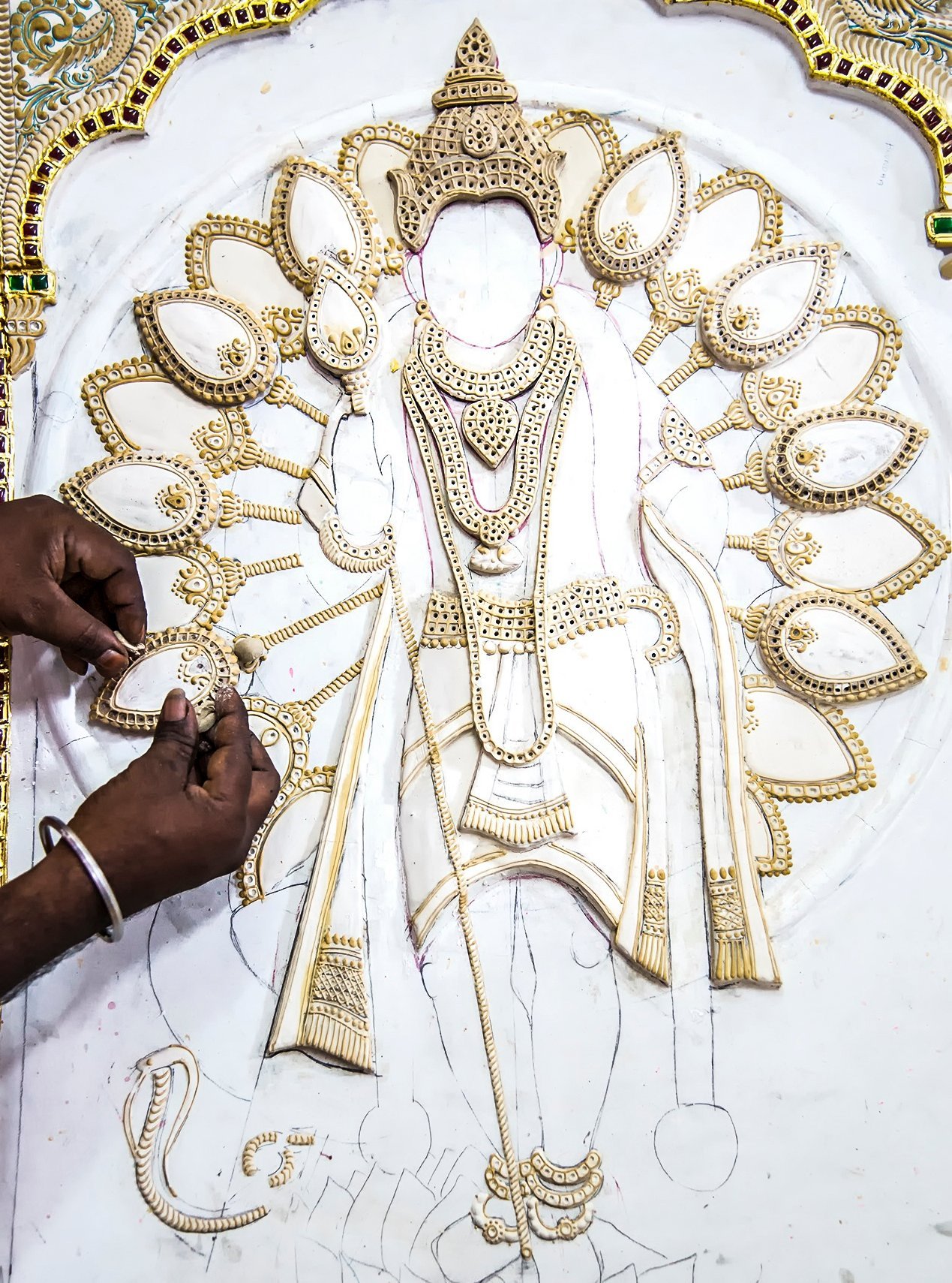 Divine art: (from far left) Artist Vijayalakshmi presents a completed artwork of Lord Rama and His royal court; Vijayalakshmi and a fellow artist present a finished painting of Lord Vishnu as Venkateswara, the presiding Deity of Venkateswara Temple in Tirupati; an artist at work in the studio; another artisan builds up raised contours that will later hold gold foil and precious stones—this relief work, known as gesso or makku, gives Thanjavur paintings their distinctive three-dimensional quality; a portrait of Goddess Samayapuram Mariamman